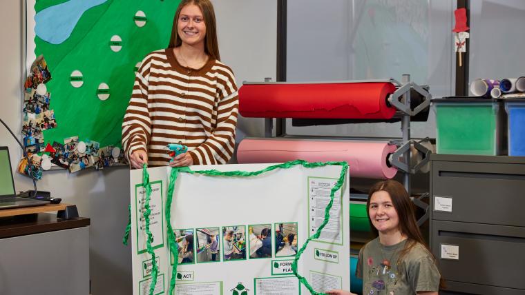 Two students presenting a trifold