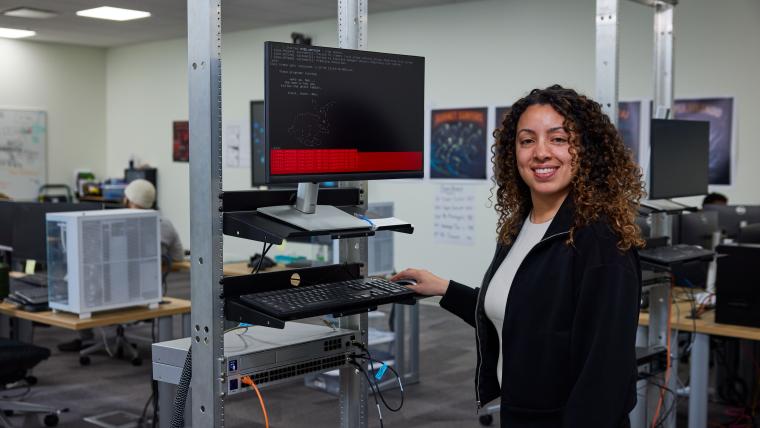 Student operating a terminal mounted to a server rack