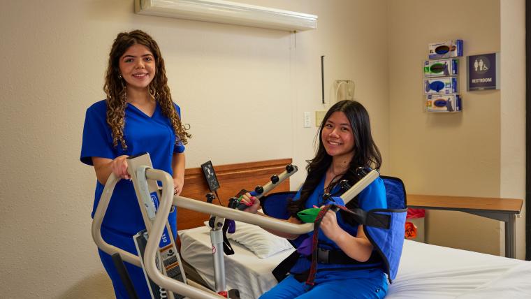 Student practicing assisting patients in a model hospital room
