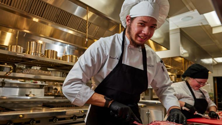 Student carving piece of meat