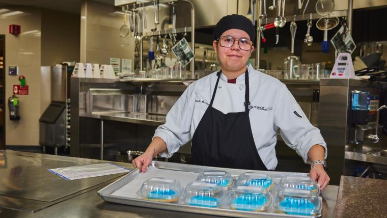 Student holding a tray of cookies