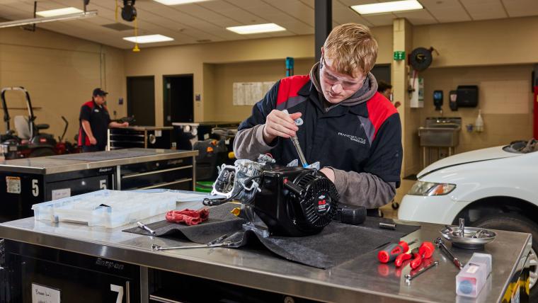 Student working on a small engine