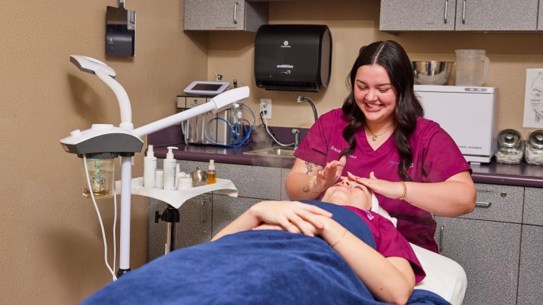 Student applying skin care products to customer's face