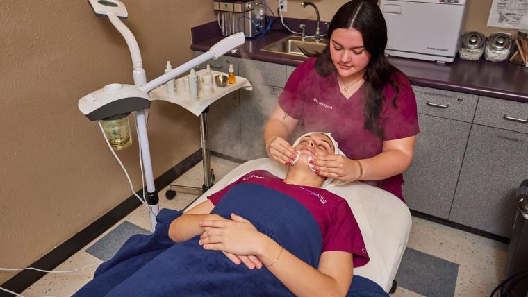 Student applying mist to customer's face