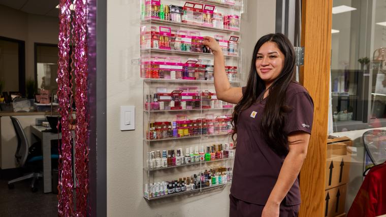 Student looking through a shelf full of nail care products