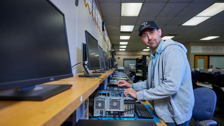 Student inspecting the inside of a desktop computer