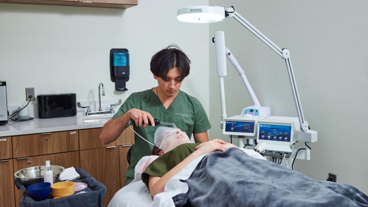 Student applying facemask to customer