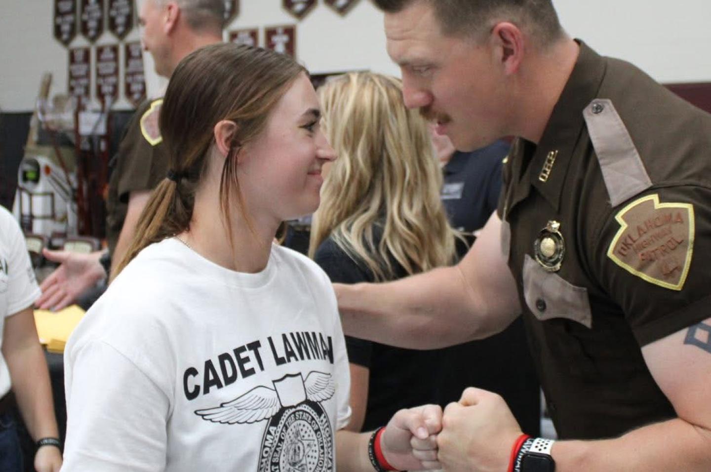 Isabell Strange interacts with a highway patrolman at the Cadet Lawman Academy
