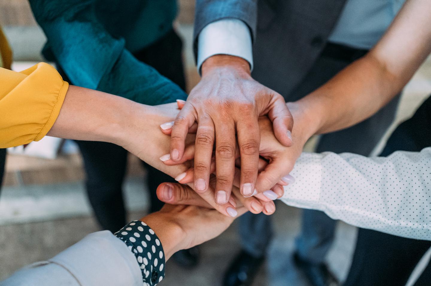 Group of people with their hands stacked.