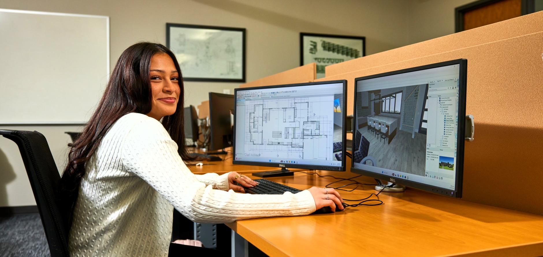 Female student working on a floor plan at a computer.
