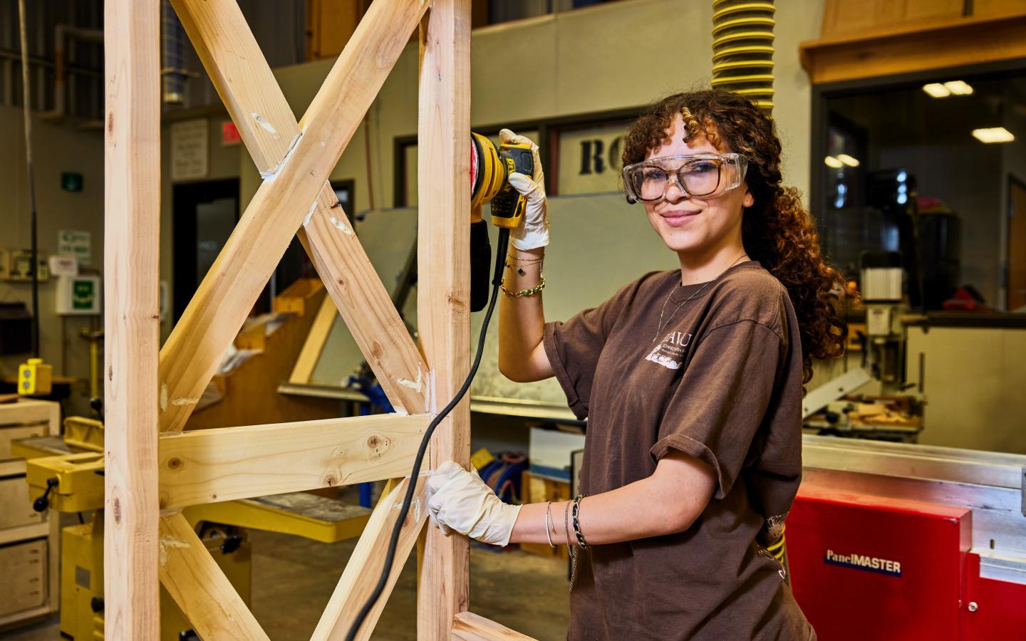 Female students using a wood sander.
