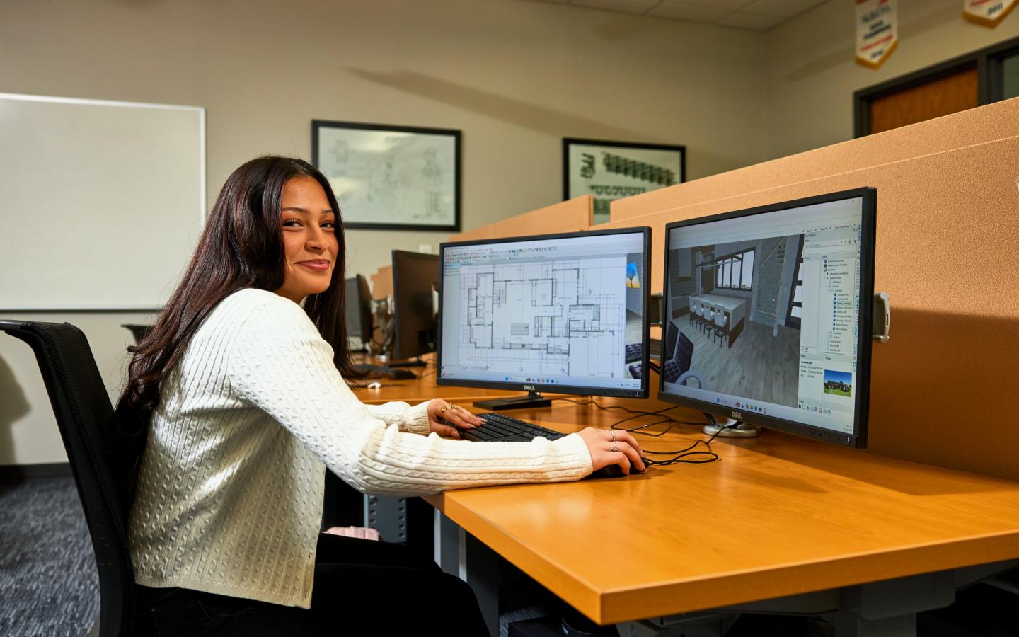 Female student working on a architecture layout on a computer.