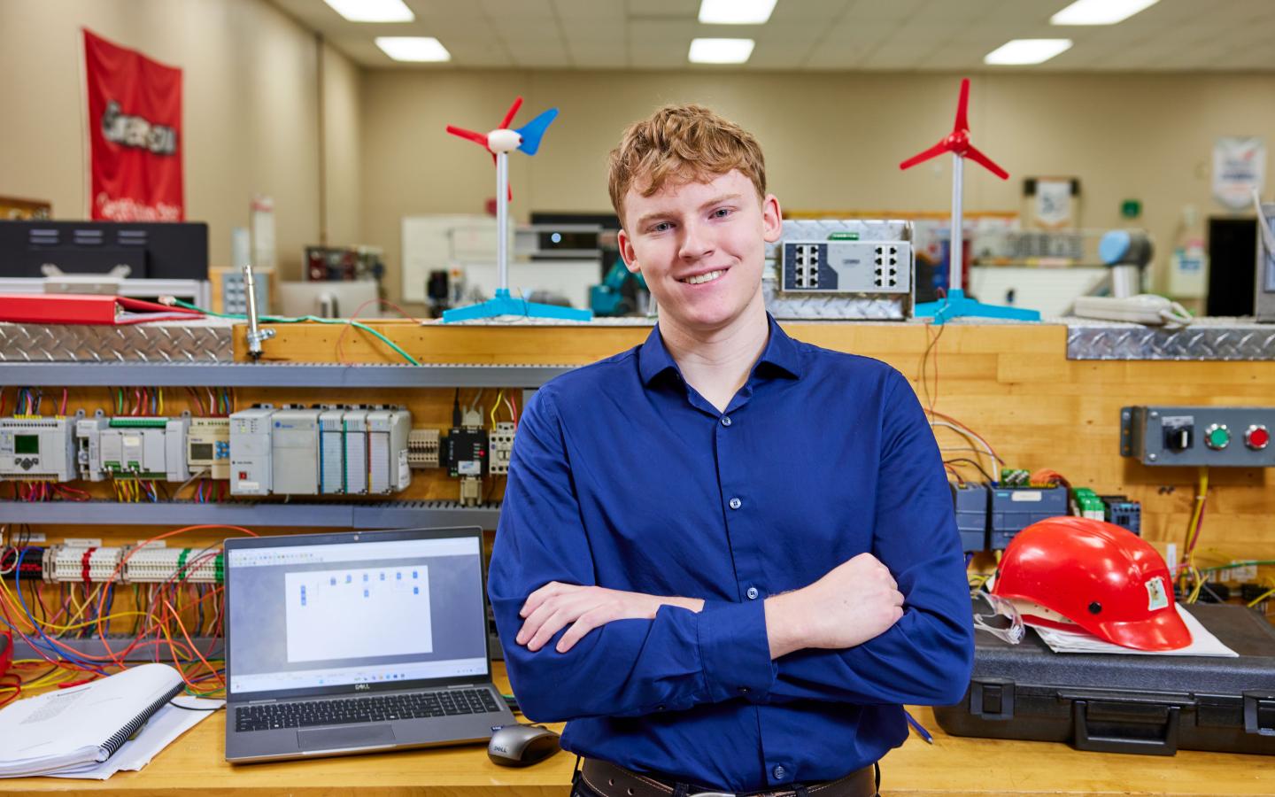 Male student standing in front of a work station