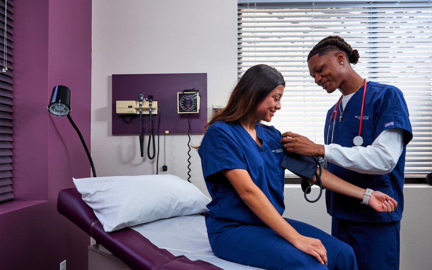 Nursing students practicing taking blood pressure.