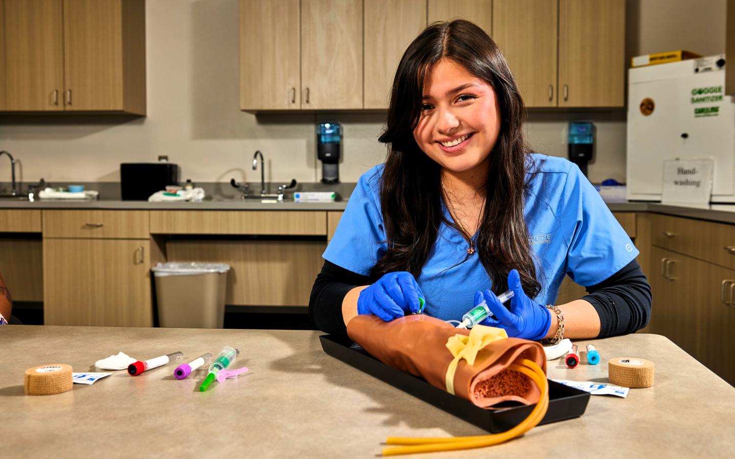 Nursing student practicing drawing blood.