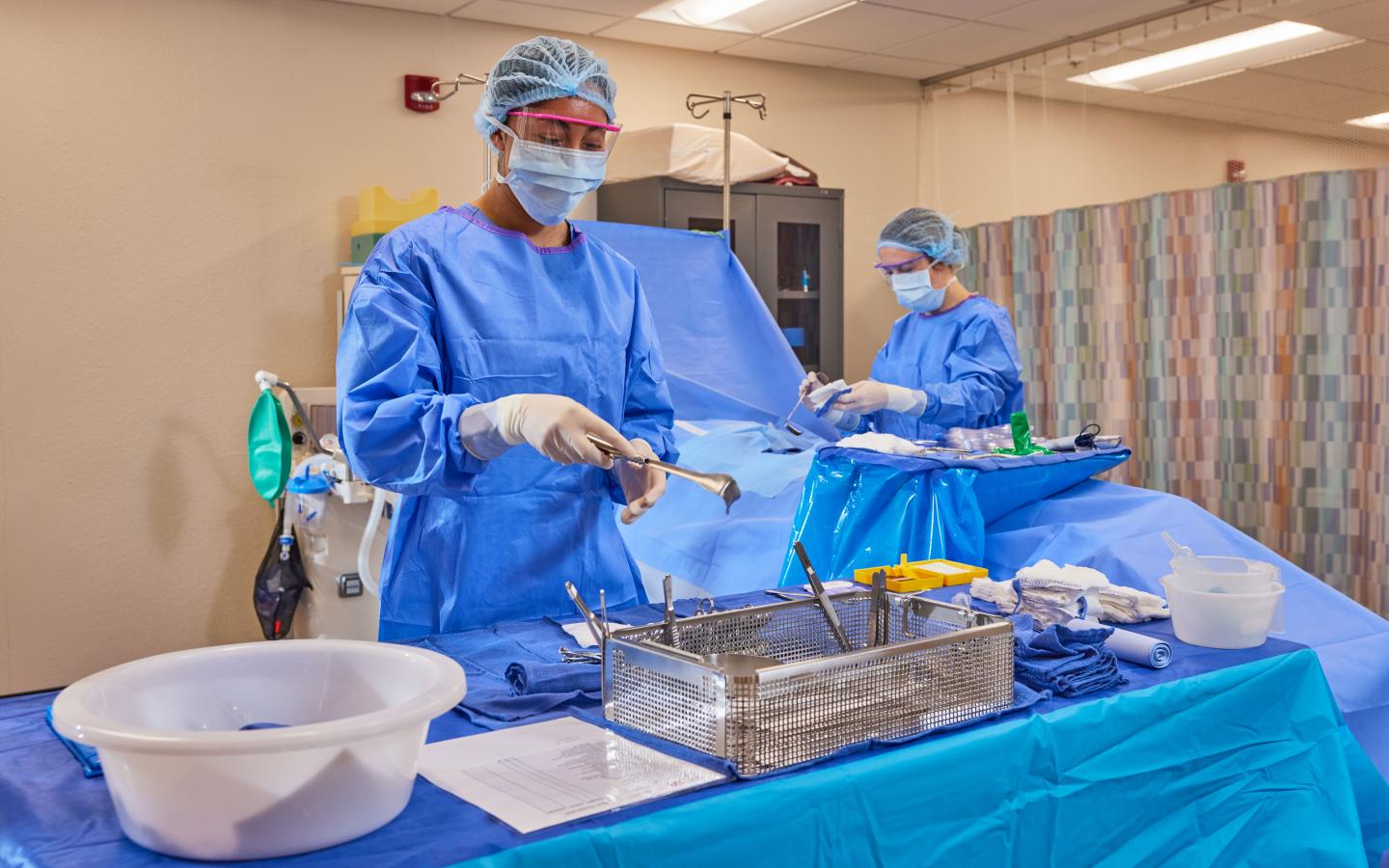 Students practicing setting up instruments for a surgery.