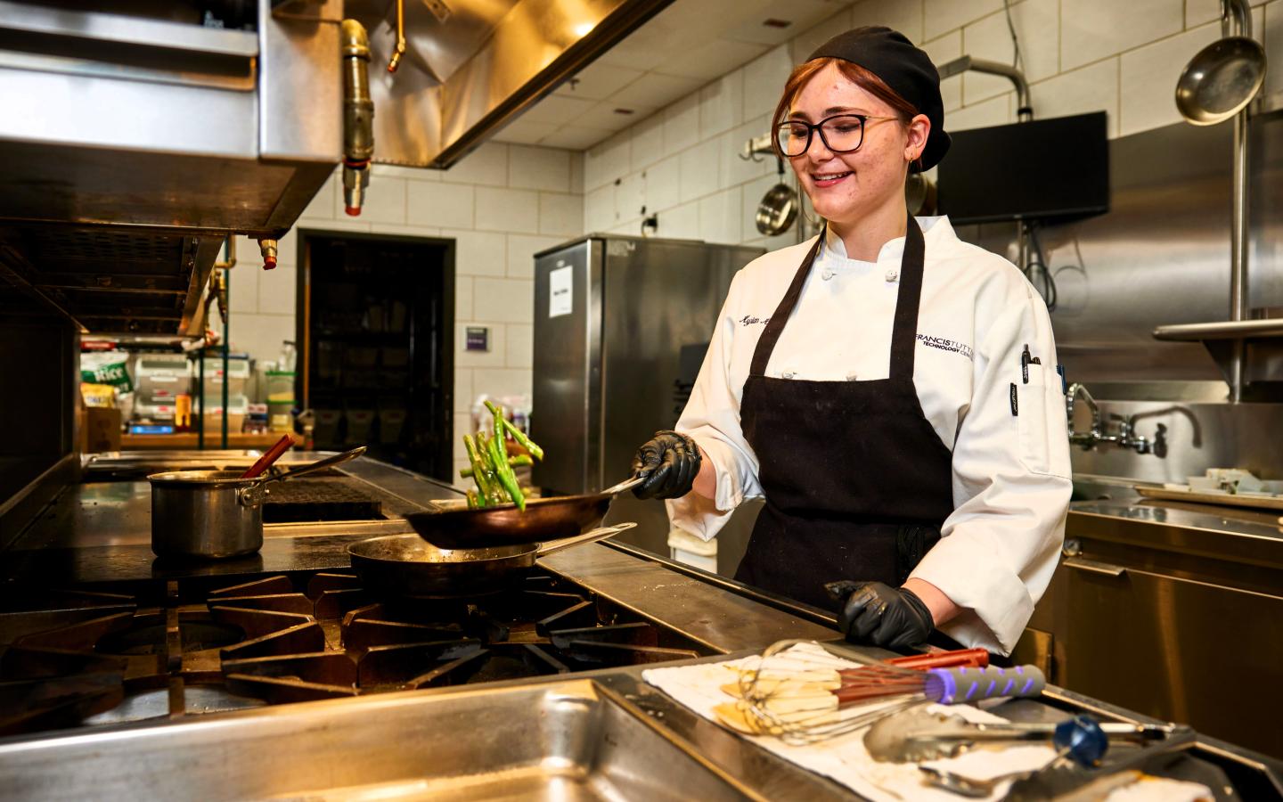 Female culinary student cooking asparagus.