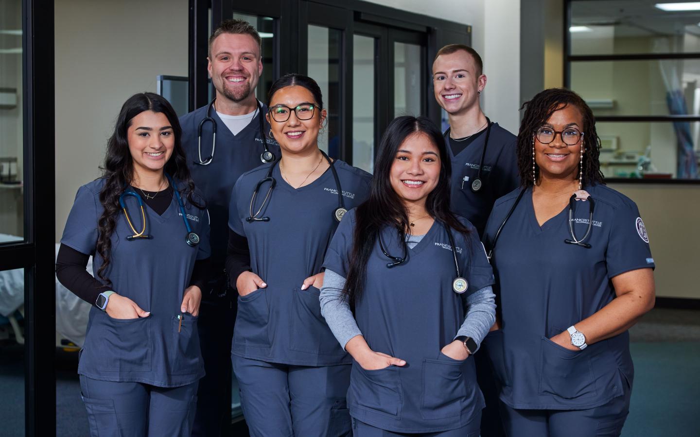 A group of male and female nursing students standing together.