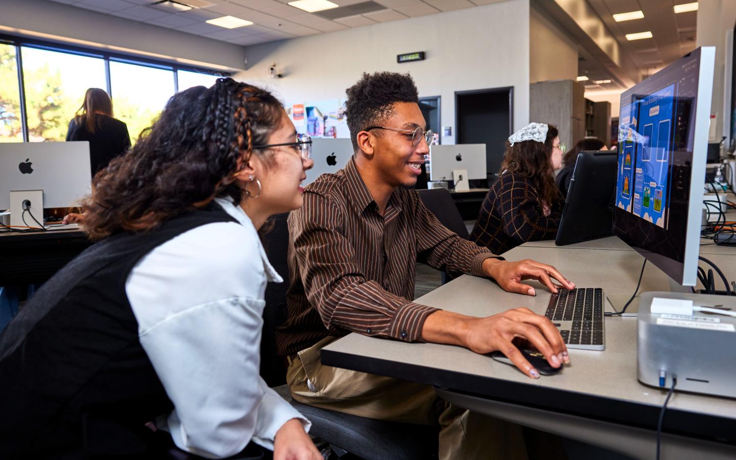 A female and male student working on a computer.