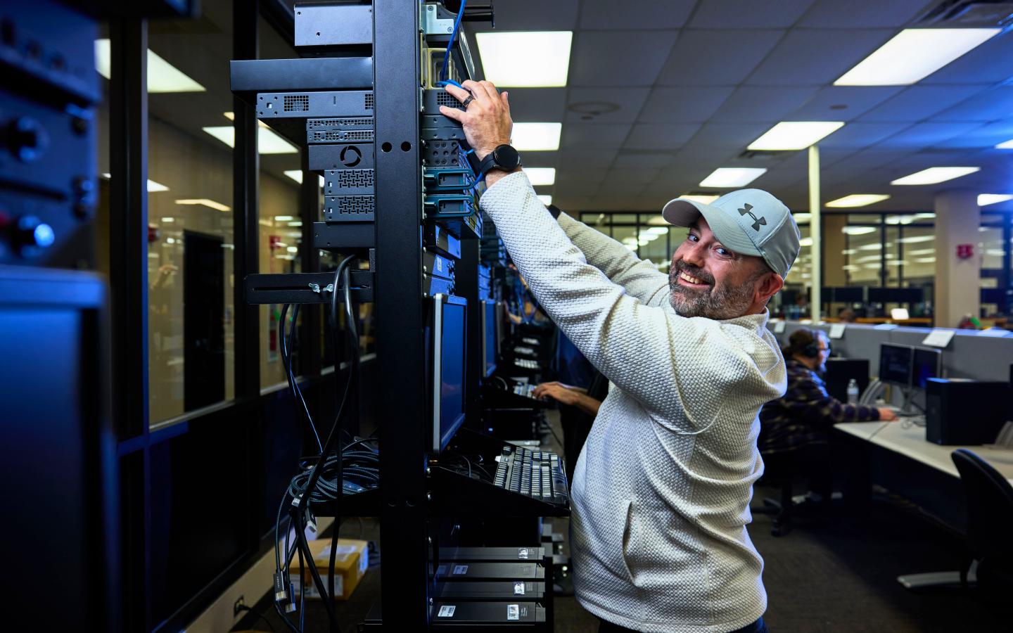 Male student working on computer connections.