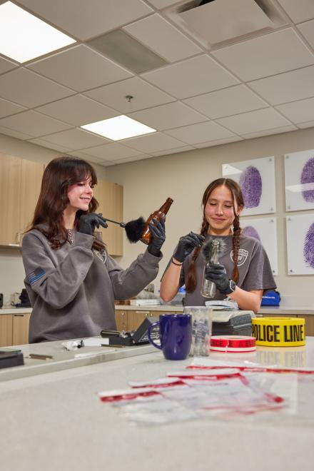 Students working on lifting finger prints off glass bottles.