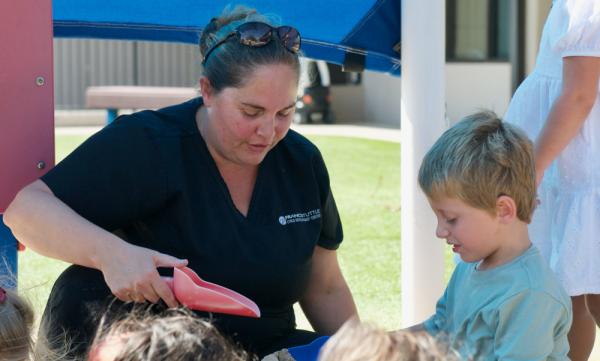 Instructor and child playing in a sandbox